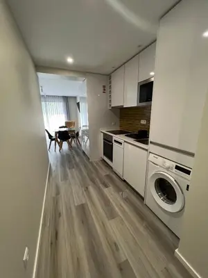 a kitchen with white cabinets and a stove top oven at Dona I Apartments at Botanical Garden in Funchal