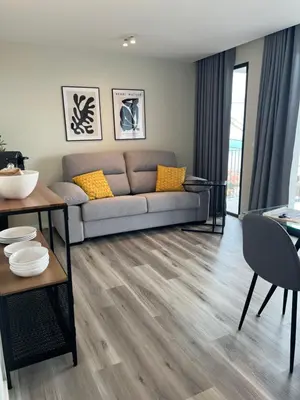 a gray couch with yellow pillows in a living room at Dona I Apartments at Botanical Garden in Funchal