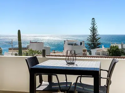 a table and chairs on a balcony with the ocean at 1Bed Apartment Amazing Sea View in Luz