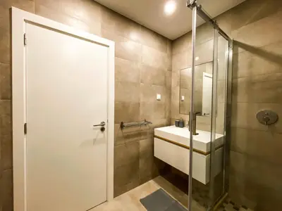 a bathroom with a sink and a glass shower door at 1Bed Apartment Amazing Sea View in Luz