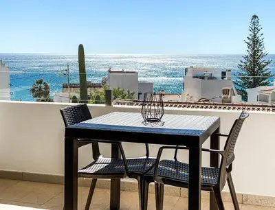 a table and chairs on a balcony with a view of the ocean at 1Bed Apartment Amazing Sea View in Luz