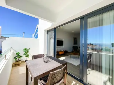 a balcony with a table and a view of a room at 1Bed Apartment Amazing Sea View in Luz