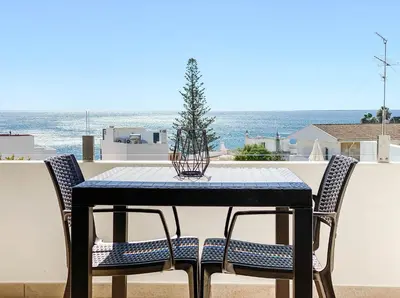 a table and chairs with a christmas tree on a balcony at 1Bed Apartment Amazing Sea View in Luz