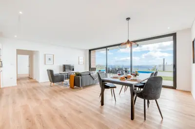 a dining room and living room with a table and chairs at Vila Inanda in Ponta do Sol