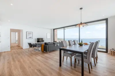 a dining room and living room with a table and chairs at Vila Inanda in Ponta do Sol