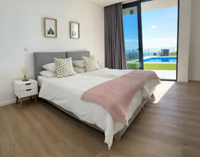 a bedroom with a large bed and a large window at Vila Inanda in Ponta do Sol
