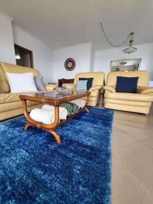 a living room with a table and a blue rug at Villa Paradise Madeira Ocean View in Fajã da Ovelha