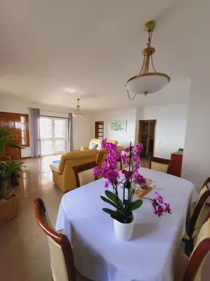 a dining room table with purple flowers on it at Villa Paradise Madeira Ocean View in Fajã da Ovelha