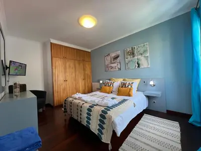 a bedroom with a bed with a blue wall at Casa Do Pico by AnaLodges in Machico
