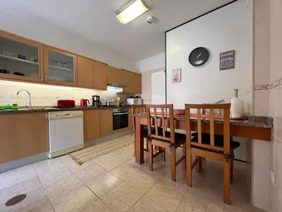a kitchen with a wooden table and chairs in it at Casa Do Pico by AnaLodges in Machico
