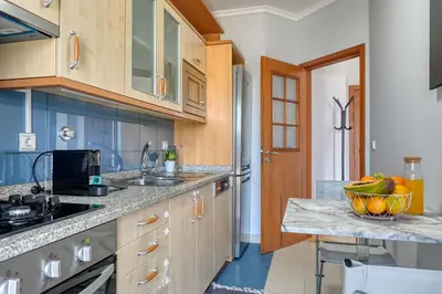 a kitchen with blue cabinets and a bowl of fruit on a counter at Forum Escape, a Home in Madeira in Funchal
