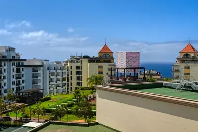 a tennis court on the roof of a building at Forum Escape, a Home in Madeira in Funchal