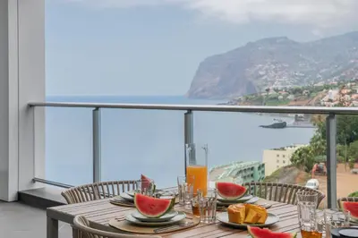 a table with watermelons on a balcony with a view at Madeira Palace I by An Island Apart in Funchal