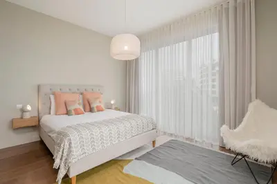 a white bedroom with a bed and a window at Madeira Palace I by An Island Apart in Funchal