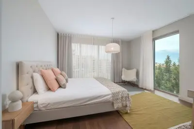 a white bedroom with a bed and a large window at Madeira Palace I by An Island Apart in Funchal