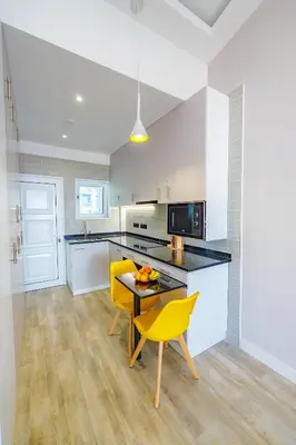 a kitchen with a table and two yellow chairs at Vista Oceano III in Caniço