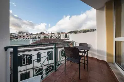 a balcony with two chairs and a table on a building at Alex Apartment by Mth in Funchal
