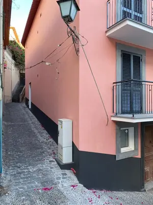 a pink building with a street light on the side at Alojamento Príncipe D.Luís in Ponta do Sol