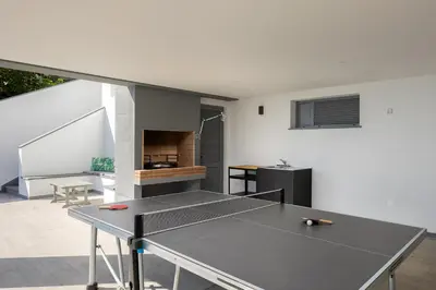 a ping pong table in the living room of a house at SKYFALL VILLA in Arco da Calheta