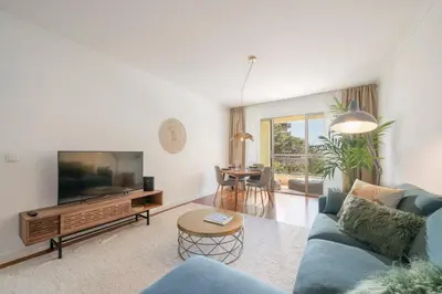 a living room with a blue couch and a tv at Quinta da Falésia II by An Island Apart in Funchal