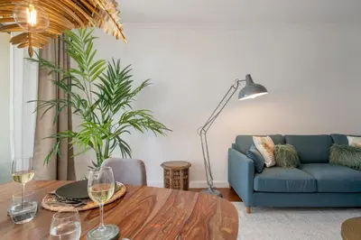 a living room with a blue couch and a table at Quinta da Falésia II by An Island Apart in Funchal