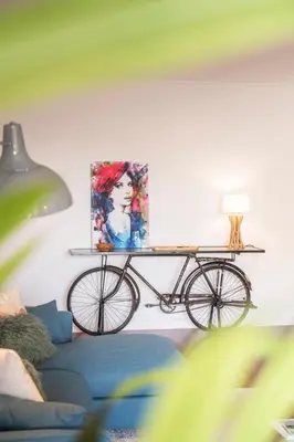 a bike on a shelf in a living room with a painting at Quinta da Falésia II by An Island Apart in Funchal