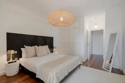 a bedroom with a large bed and a chandelier at Quinta da Falésia II by An Island Apart in Funchal