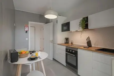 a kitchen with a small table and a white kitchen at Quinta da Falésia II by An Island Apart in Funchal