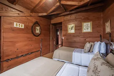 two beds in a room with wooden walls at Villa Achada da Mouca by Homie in Santana