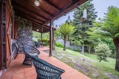 a porch with two benches and a stone wall at Villa Achada da Mouca by Homie in Santana