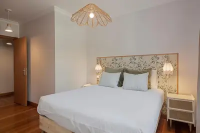 a bedroom with a large white bed and a chandelier at Monumental Place by An Island Apart in Funchal