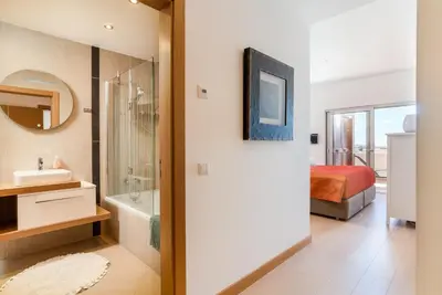 a bathroom with a shower and a bed and a tub at Spacious 2 bedroom Apartment with Sea View Lagos by Lisbeyond in Lagos