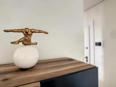 a bronze statue sitting on top of a white vase at The Best Sea View Apartment by LovelyStay in Funchal