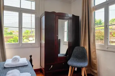 a bedroom with a mirror and a bed and a chair at Os Ferreirinhos, a Home in Madeira in São Jorge