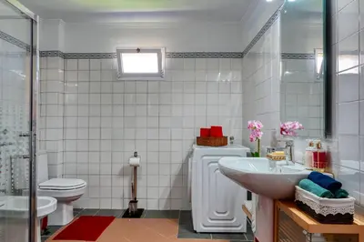 a white bathroom with a sink and a toilet at Os Ferreirinhos, a Home in Madeira in São Jorge