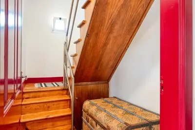 a room with a staircase with a bed and a stair case at Os Ferreirinhos, a Home in Madeira in São Jorge