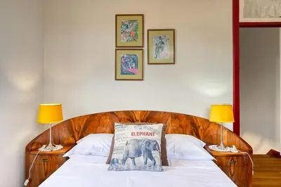 a bed with a pillow on it with two lamps at Os Ferreirinhos, a Home in Madeira in São Jorge