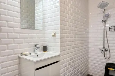 a white bathroom with a sink and a shower at Os Ferreirinhos, a Home in Madeira in São Jorge