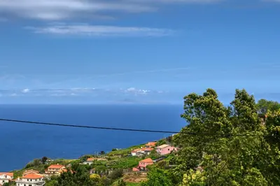 a town on a hill with the ocean in the background at Os Ferreirinhos, a Home in Madeira in São Jorge