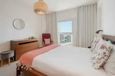 a bedroom with a bed and a desk and a window at Santa Luzia II by An Island Apart in Funchal