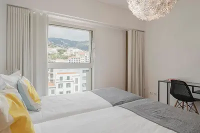 a bedroom with a bed and a large window at Santa Luzia II by An Island Apart in Funchal
