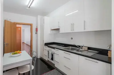 a kitchen with white cabinets and a bowl of fruit on a counter at Santa Luzia II by An Island Apart in Funchal