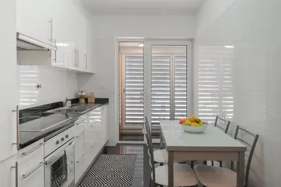 a kitchen with a table with a bowl of fruit on it at Santa Luzia II by An Island Apart in Funchal