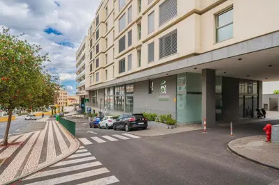 a street with cars parked in front of a building at Santa Luzia II by An Island Apart in Funchal