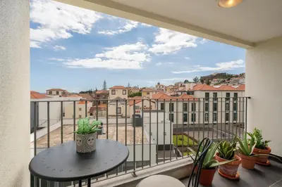 a balcony with a table and a view of a city at Santa Luzia II by An Island Apart in Funchal