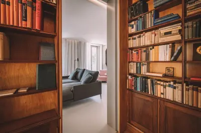 a living room with a couch and a book shelf with books at VILLA QUINTA TORRINHA Rooms in Funchal