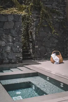 a purse sitting next to a pool of water at VILLA QUINTA TORRINHA Rooms in Funchal