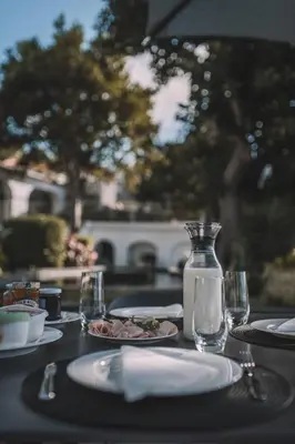 a table with plates of food and a glass bottle at VILLA QUINTA TORRINHA Rooms in Funchal