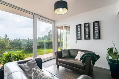 a living room with a couch and a large window at Villa Valeriu in Santa Cruz