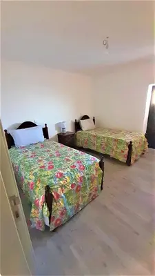 a bedroom with two beds with flowers on them at Casa Magic Vieira New well located with services in Arco da Calheta